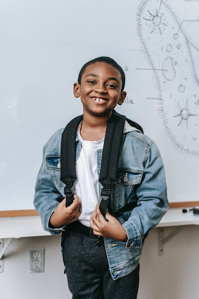 Child smiling in front of white board